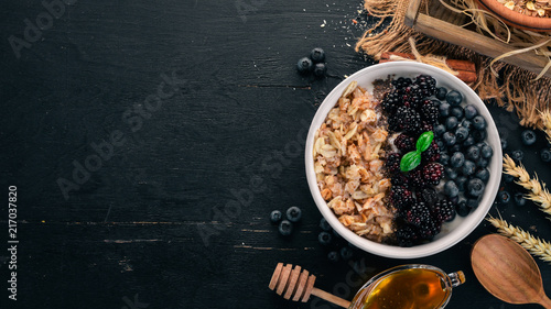 Oatmeal with blueberries and blackberry. On a wooden background. Top view. Free space for text.