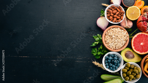 Healthy food clean eating selection: Vegetables, fruits, nuts, berries and mushrooms, parsley, spices. On a black background. Free space for text. photo