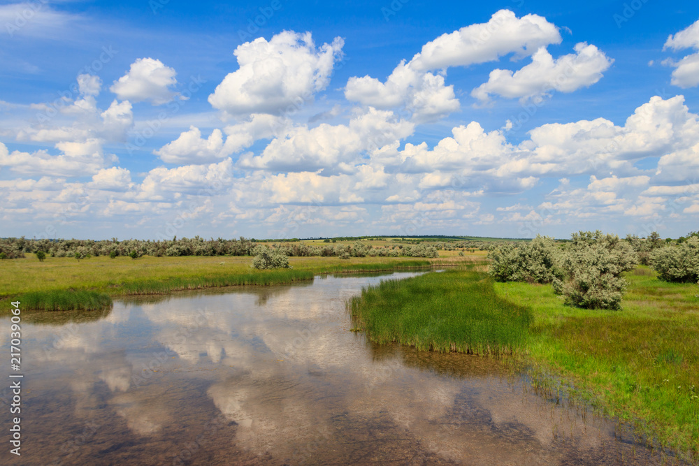 Summer landscape with small river and blue cloudy sky Summer landscape with small river and blue cloudy sky