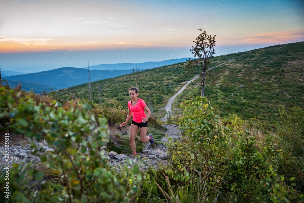Woman trail running in mountains.
