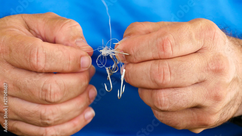 Obraz na plátně Man unraveling to the tangled and knotted Fishing line