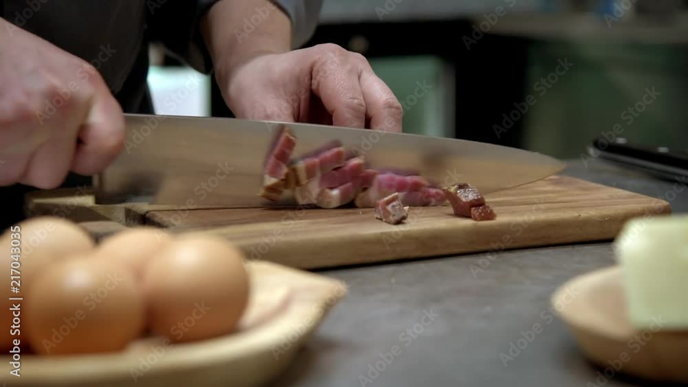 Chef slicing raw pork bacon on wood board Chef slicing raw pork bacon on wood board