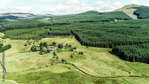 Tela Aerial image of stream winding through moorland with conifer plantations in the distance