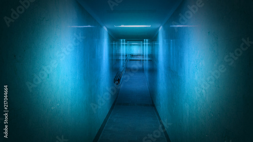 Tunnel, a long corridor at the end of which is light. Basement with illuminated walls. Neon