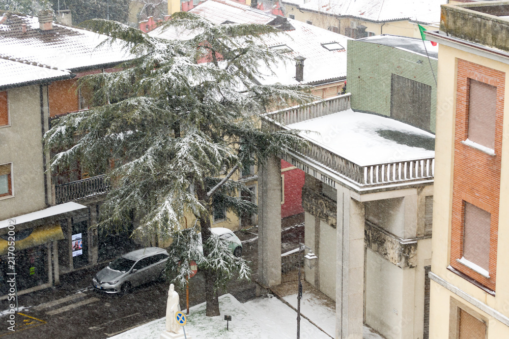 Fototapeta premium Winter unusual aerial landscape of Rovigo in Veneto in the Po valley, Italy. During a snowfall the city roofs got white even the historic landmark the 