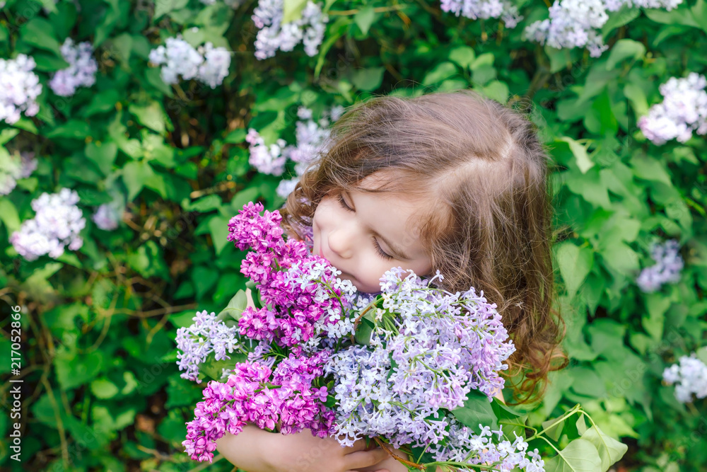 happy girl holding a bouquet of lilac. happy mother's Day! girl congratulates her mother, gives a bouquet of lilac flowers.	