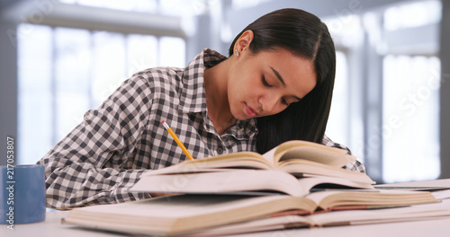 Fotografie Hispanic female college student studies for an exam at her campus study hall