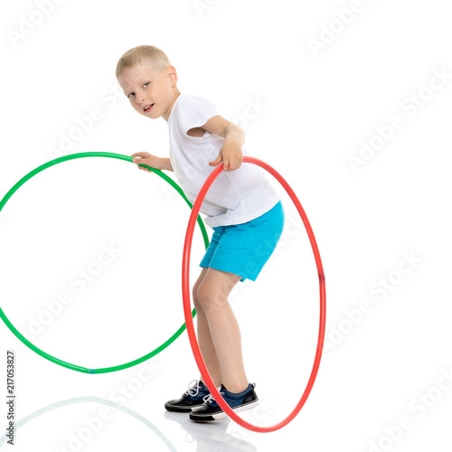 A little boy is playing with a hoop.