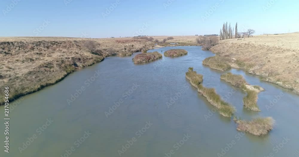 Low flight over shallow river with grass islands Low flight over shallow river with grass islands
