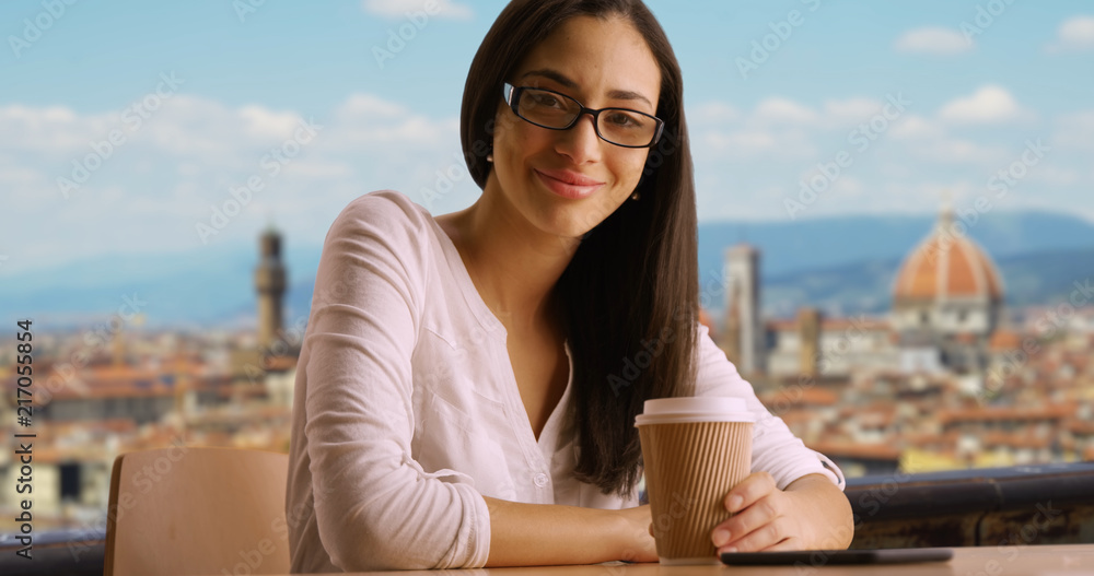 Cute Latina tourist holds coffee cup view of Florence cityscape in background