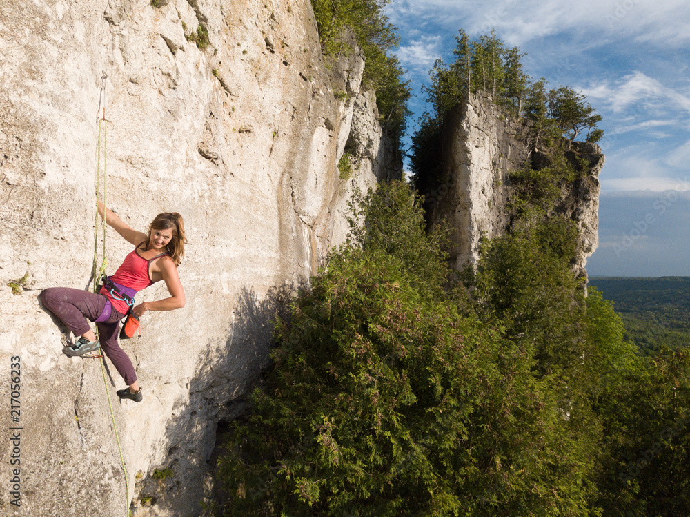 Obraz premium A beautiful woman rock climbing in Ontario, Canada.