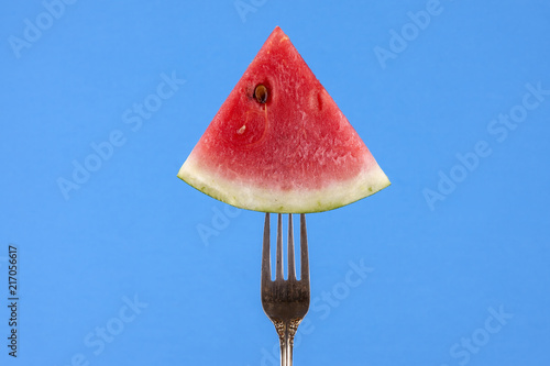 Watermelon slice displayed on fork.