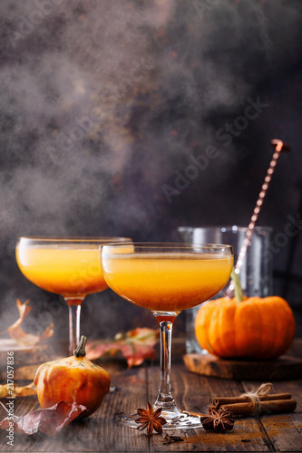 Autumn pumpkin cocktail on wooden table. 