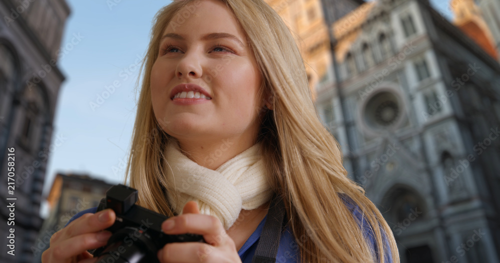 Happy white female traveling in Florence takes photos near Florence Cathedral