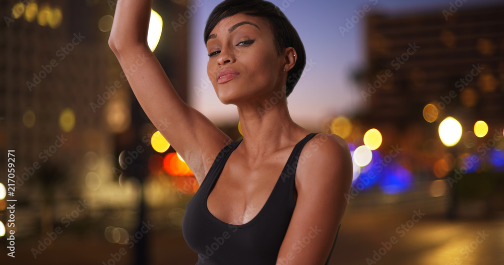 Gorgeous African female dancing with grace outside in metropolitan city Gorgeous African female dancing with grace outside in metropolitan city