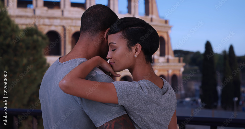 Black boyfriend and girlfriend in Rome chatting in front of the Colosseum