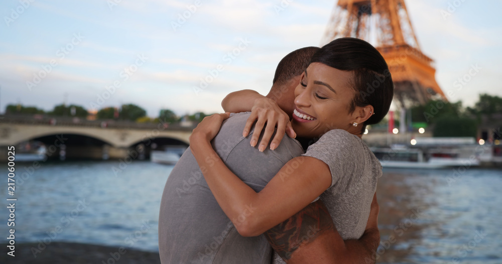 Tender African couple embracing by Seine River near Eiffel Tower Tender African couple embracing by Seine River near Eiffel Tower