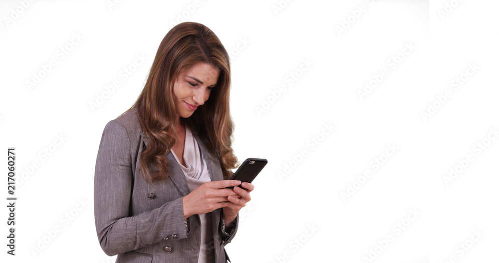Portrait of white brunette reading text message on cellphone on white background Portrait of white brunette reading text message on cellphone on white background