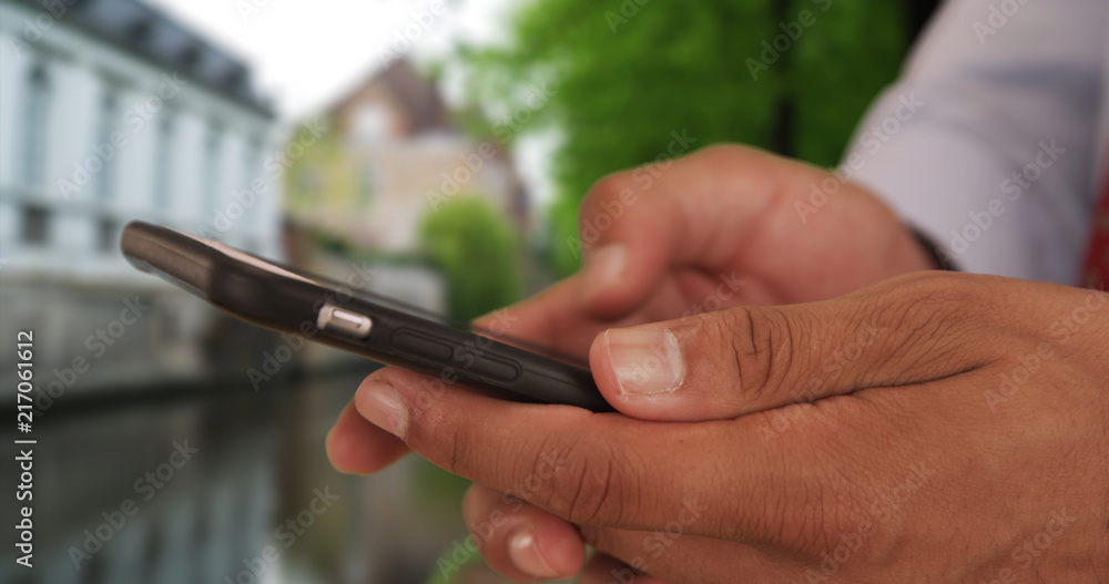 Close up of Latino businessman text messaging on smart phone