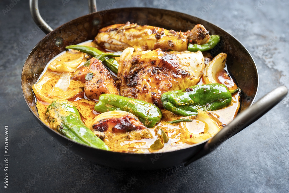 Traditional Thai kaeng massaman coconut chicken curry with jalapeno, poblano chili and sweet potatoes as closeup in a traditional bowl Traditional Thai kaeng massaman coconut chicken curry with jalapeno, poblano chili and sweet potatoes as closeup in a traditional bowl