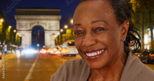 Canvas Print Beautiful mature black woman on Paris street at night smiling at camera