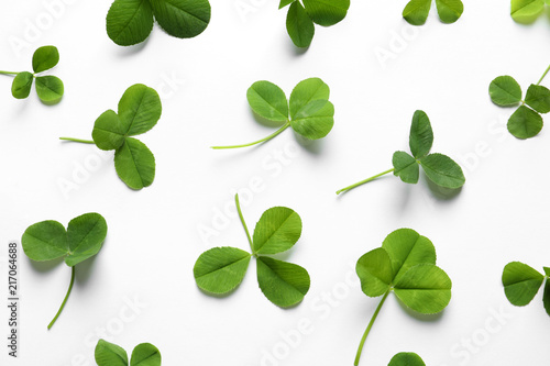 Flat lay composition with green clover leaves on white background, top view
