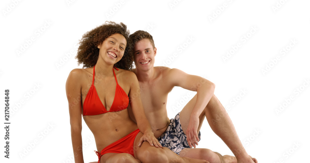 Portrait of happy multiethnic beach couple relaxing on white background
