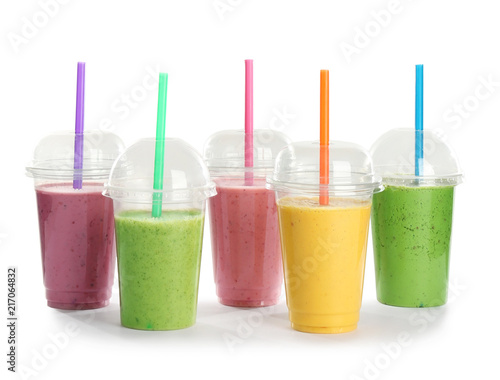Plastic cups with fresh tasty smoothies on white background