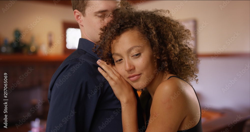 Happy multiethnic couple dance inside their living room Happy multiethnic couple dance inside their living room