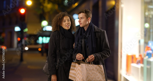 Happy young couple shopping in the city at night