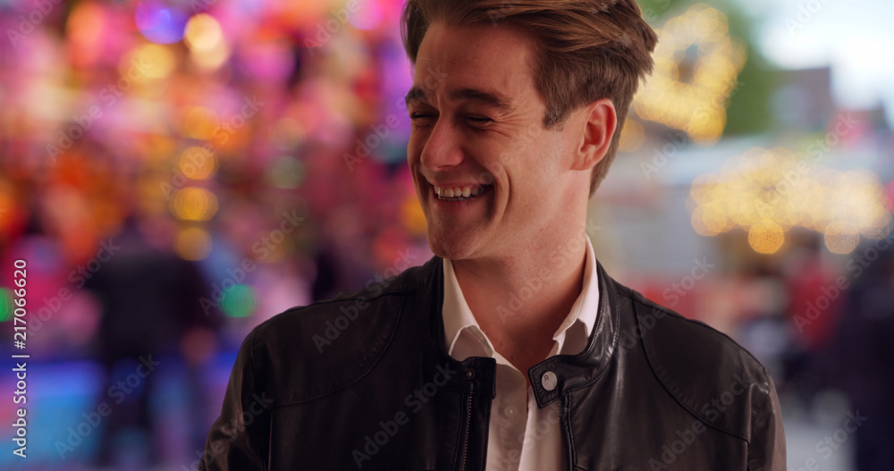 Fototapeta premium Cool and handsome young man at county fair smiling and laughing at camera
