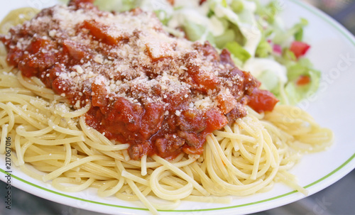Cooked spaghetti pasta topped with a delicious homemade meat sauce and freshly grated Parmesan cheese and a fresh garden side salad topped with creamy Ranch dressing 