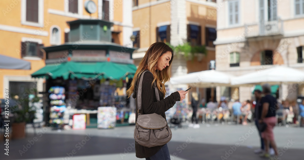 Caucasian girl in her 20s using cellphone for directions Caucasian girl in her 20s using cellphone for directions