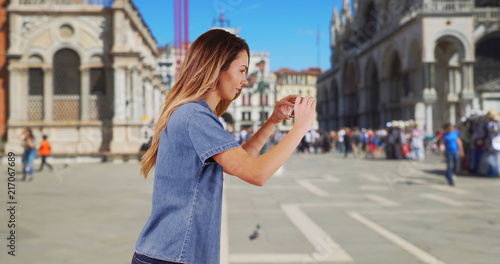 Happy woman tourist taking picture in San Marco Piazza with smartphone © rocketclips