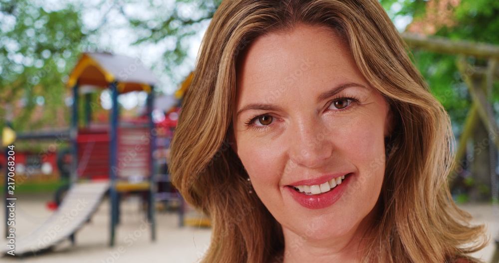 Close up of Caucasian woman with bright smile outside at park Close up of Caucasian woman with bright smile outside at park