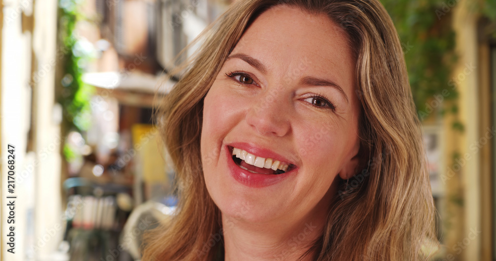 Close up portrait of Caucasian woman laughing and smiling outside Close up portrait of Caucasian woman laughing and smiling outside