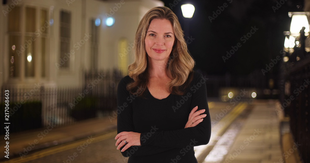 Smiling Caucasian woman posing for a portrait outside at night Smiling Caucasian woman posing for a portrait outside at night