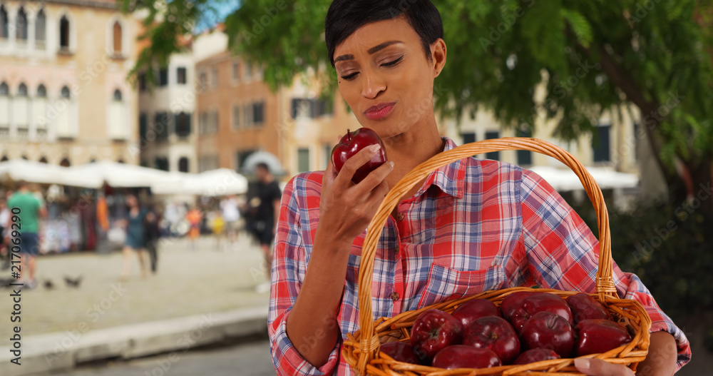 Portrait of healthy attractive black female biting into juicy apple