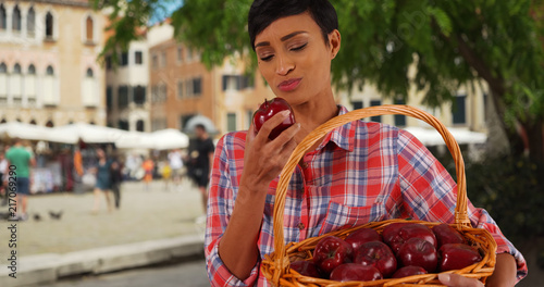 Portrait of healthy attractive black female biting into juicy apple