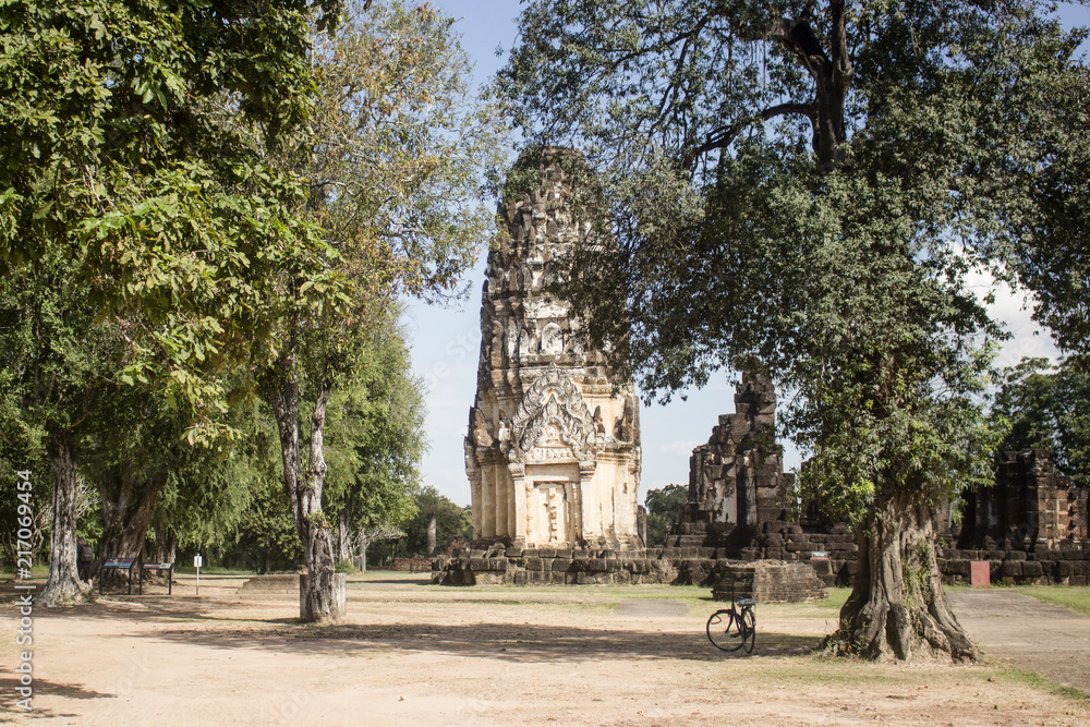 Intricate stupa surrounded by beautiful trees in Wat Phra Phai temple. Sukhothai Historical Park, Thailand.