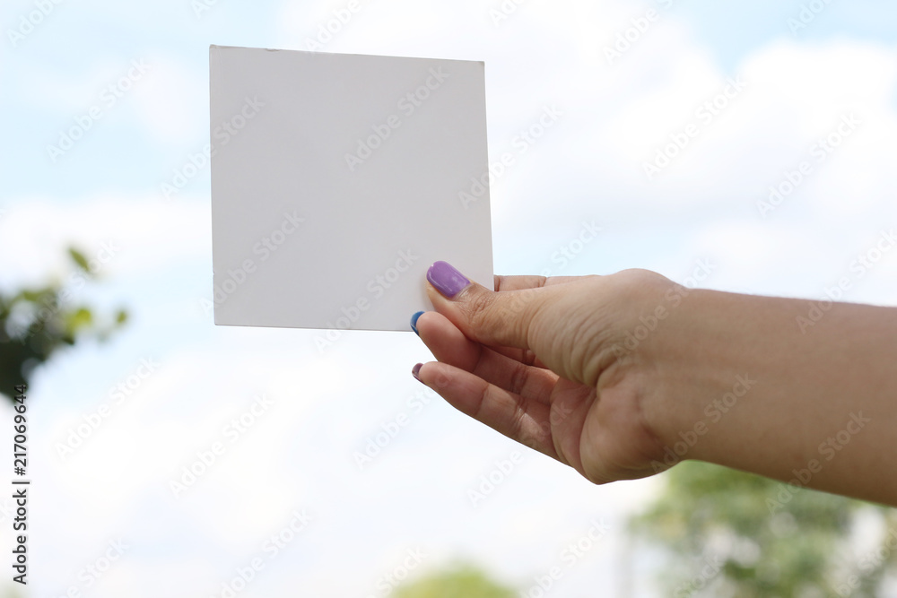 Hand hold white blank business card on green background Hand hold white blank business card on green background
