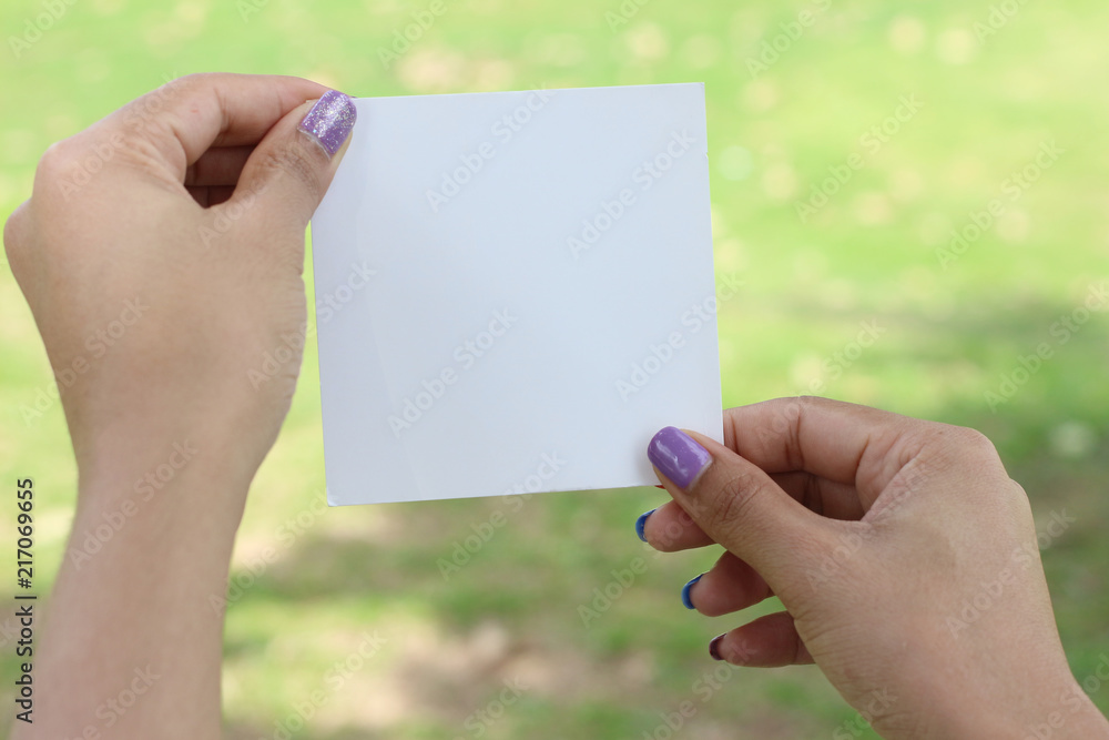 Hand hold white blank business card on green background Hand hold white blank business card on green background