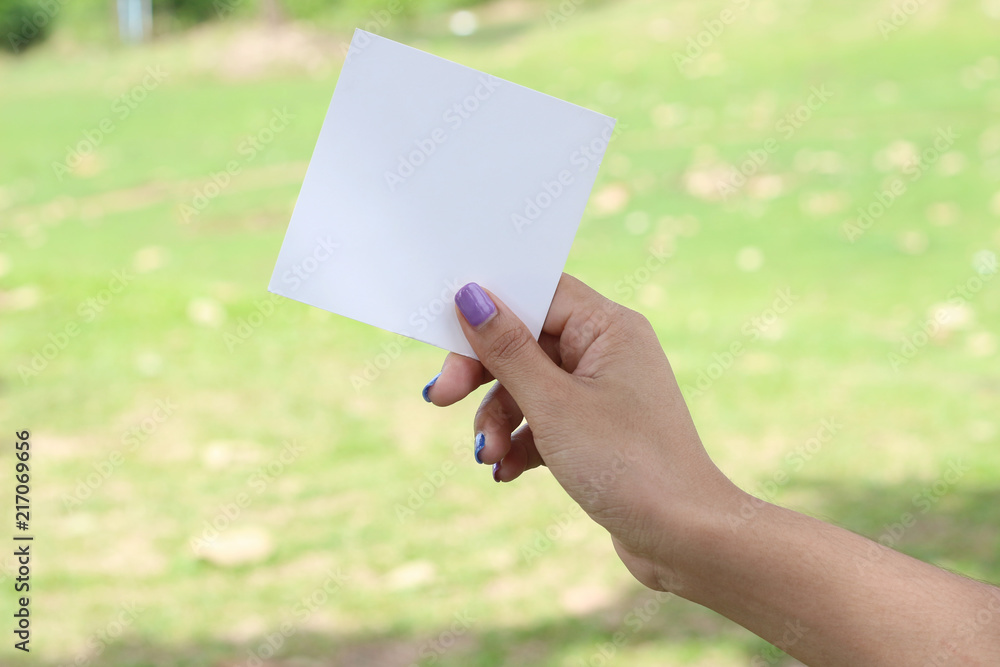 Hand hold white blank business card on green background Hand hold white blank business card on green background