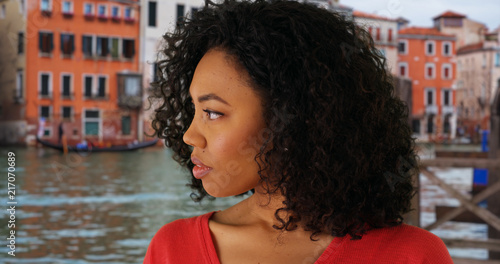 Somber looking black female looking away from camera while in Venice Italy