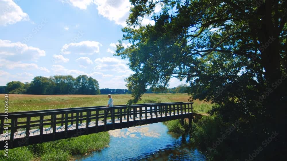Girl walking across a picturesque bridge in Assen, Netherlands, SLOWMO ZOOM OUT Girl walking across a picturesque bridge in Assen, Netherlands, SLOWMO ZOOM OUT
