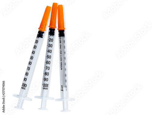 Plastic insulin syringes for diabetes. Needle for addict. Three insulin syringes with orange cover isolated on white background. Injection medicine. Medical equipment for diabetic. Vaccination concept photo