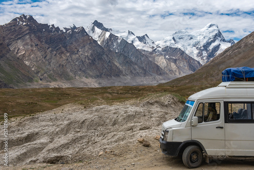 Beautiful landscape of Penzi la pass with a van car and suitcase in summer on the way of Zanskar valley road , Ladakh, India.