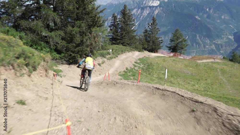 Person cycling on mountain trail with downhill bike Person cycling on mountain trail with downhill bike