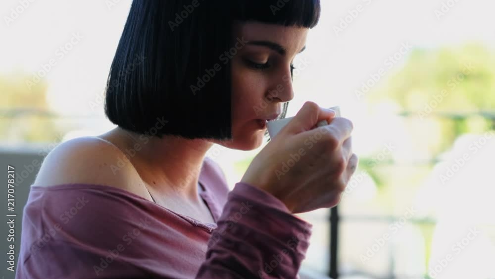 Woman having coffee while reading a book in the balcony 4k Woman having coffee while reading a book in the balcony 4k
