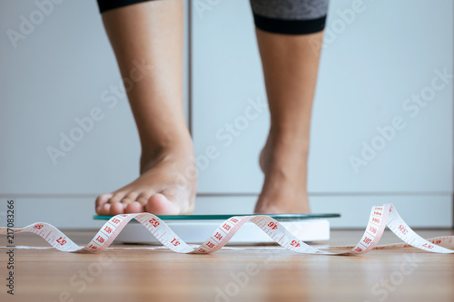 Canvas Print Woman foot stepping on weigh scales with tape measure,Weight loss,Body and good